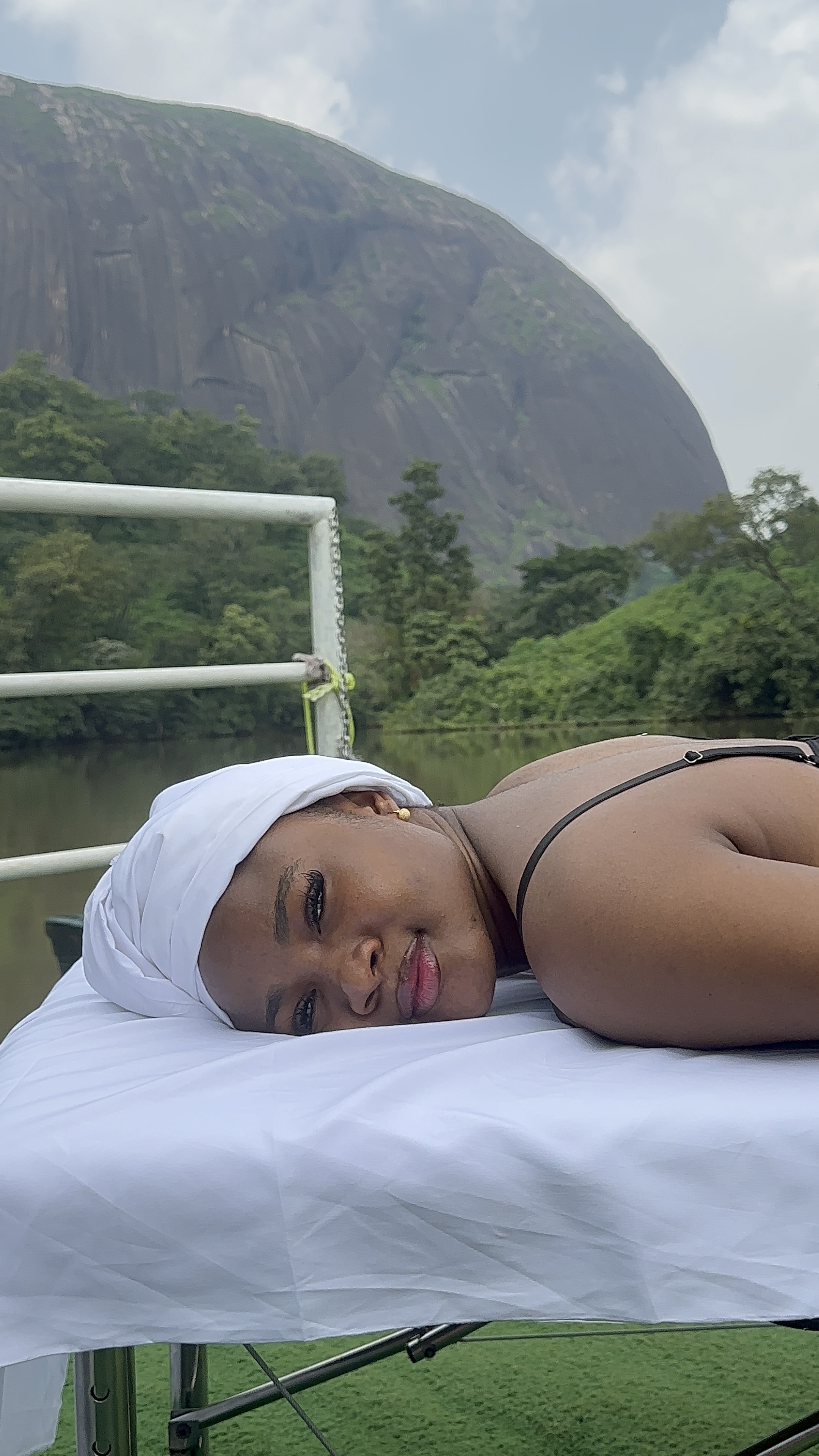 Guest resting on a treatment bed with a mountain behind