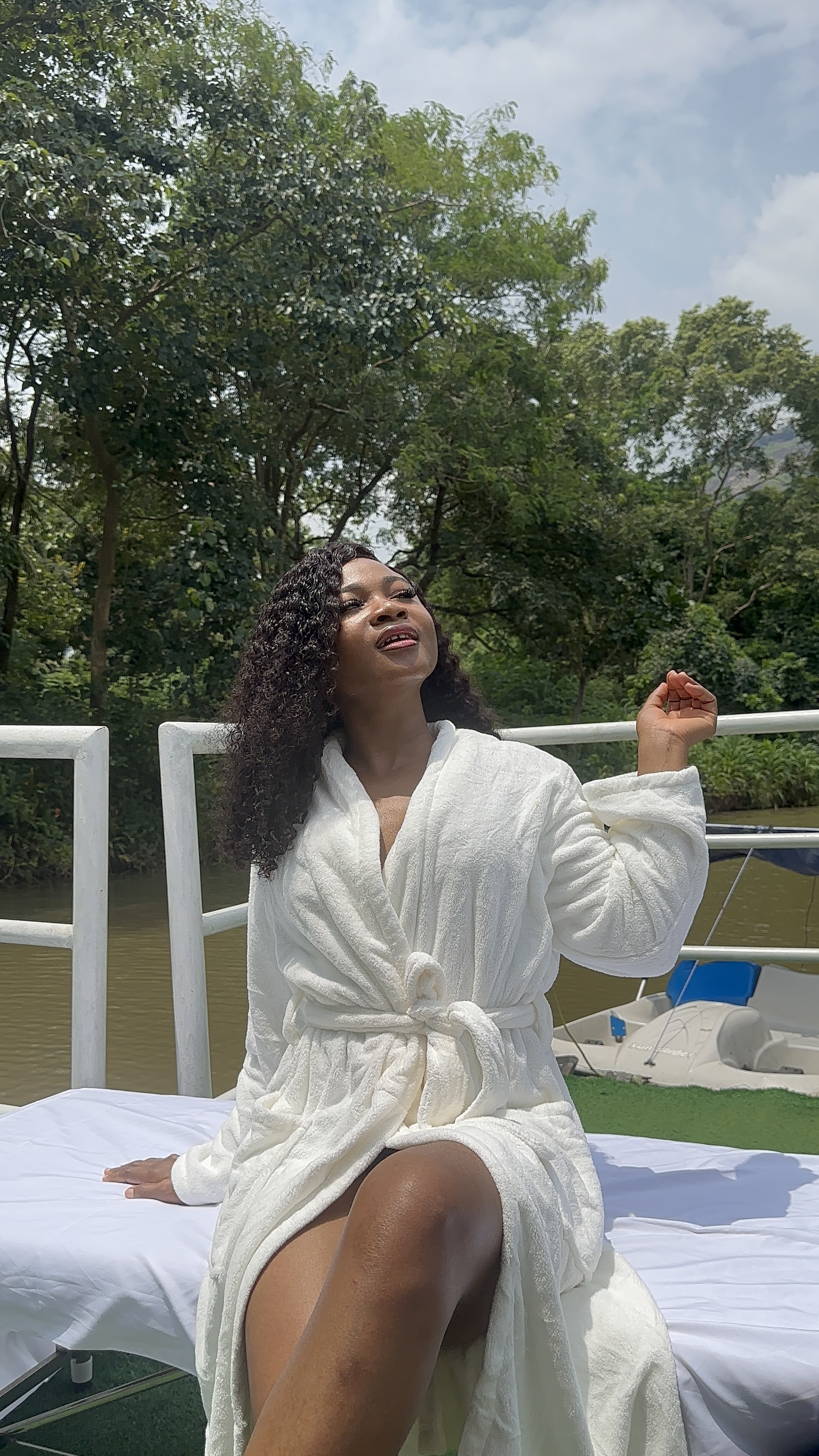 Guest in a white robe relaxing by the riverside